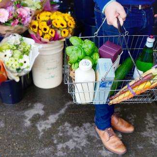 person in blue denim jeans and brown leather boots holding green plastic bag by Tara Clark courtesy of Unsplash.